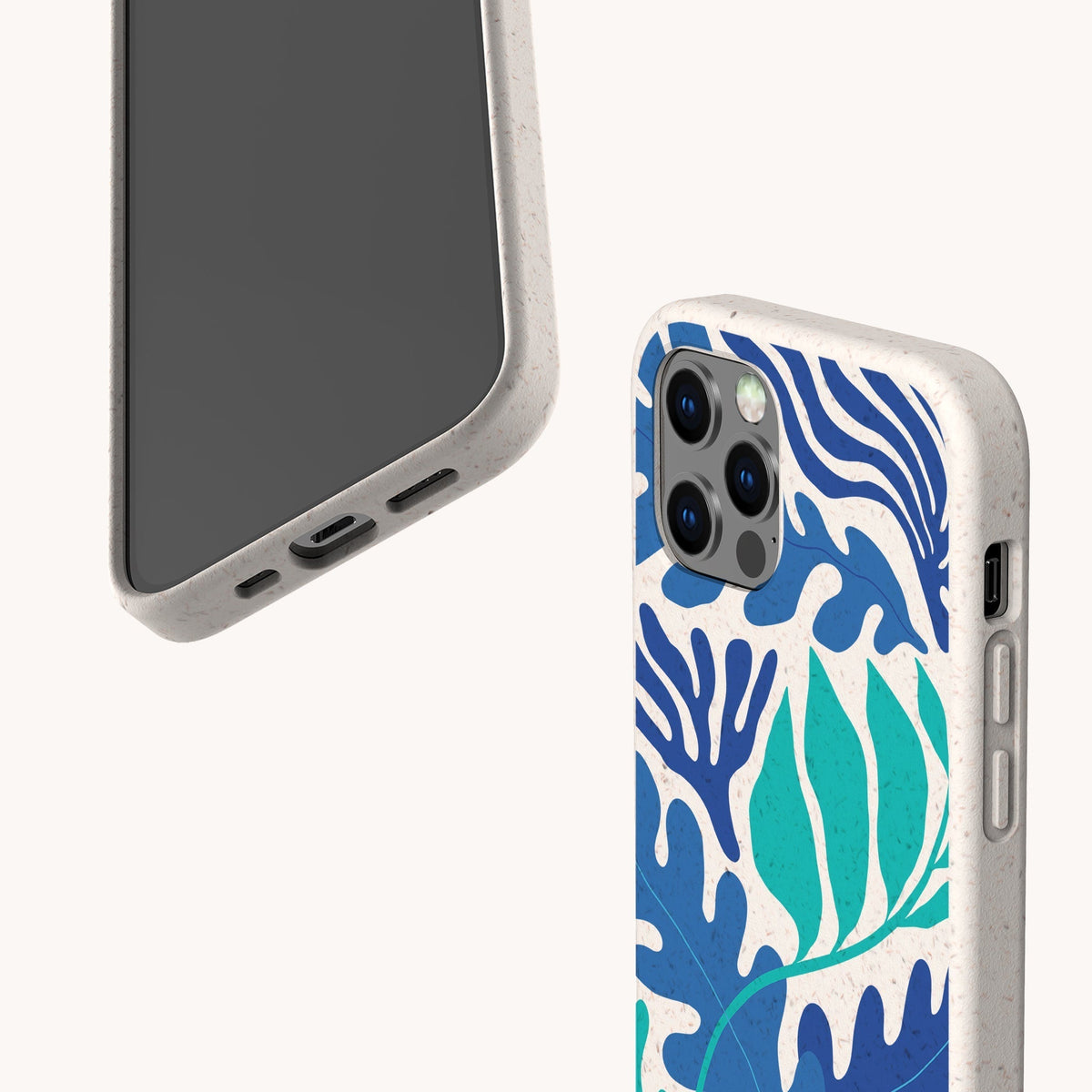 Two smartphones with beige speckled, compostable phone cases are displayed on a white background; one case is the Sea Bed Eco-Friendly Phone Case, featuring a blue and teal abstract leaf pattern inspired by the ocean, while the other is plain. Both eco-friendly phone cases are shown from different angles.