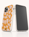 Two smartphones in white, each fitted with the Orange Hearts Eco-Friendly Biodegradable Phone Case featuring an orange and pink heart pattern. One phone highlights the patterned back of this sustainable case, while the other displays its plain black screen and side buttons. The background is white.