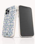 Two smartphones in white cases adorned with a blue and green floral pattern—one showcasing the back design of the Blue Ditsy Flowers Eco-Friendly Biodegradable Phone Case, while the other reveals its blank black screen. This sustainable accessory blends charming florals with eco-friendly, biodegradable materials for a stylish yet conscious phone case option.