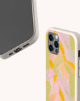 Two smartphones are shown in pastel-toned, speckled cases. One displays the front and side ports, while the other reveals the back with a soft abstract pattern featuring pink, yellow, green, and orange shades. These are Peach Sorbet Eco-Friendly Phone Cases—biodegradable and compatible with both iPhone and Samsung devices—for effortless style and sustainability.