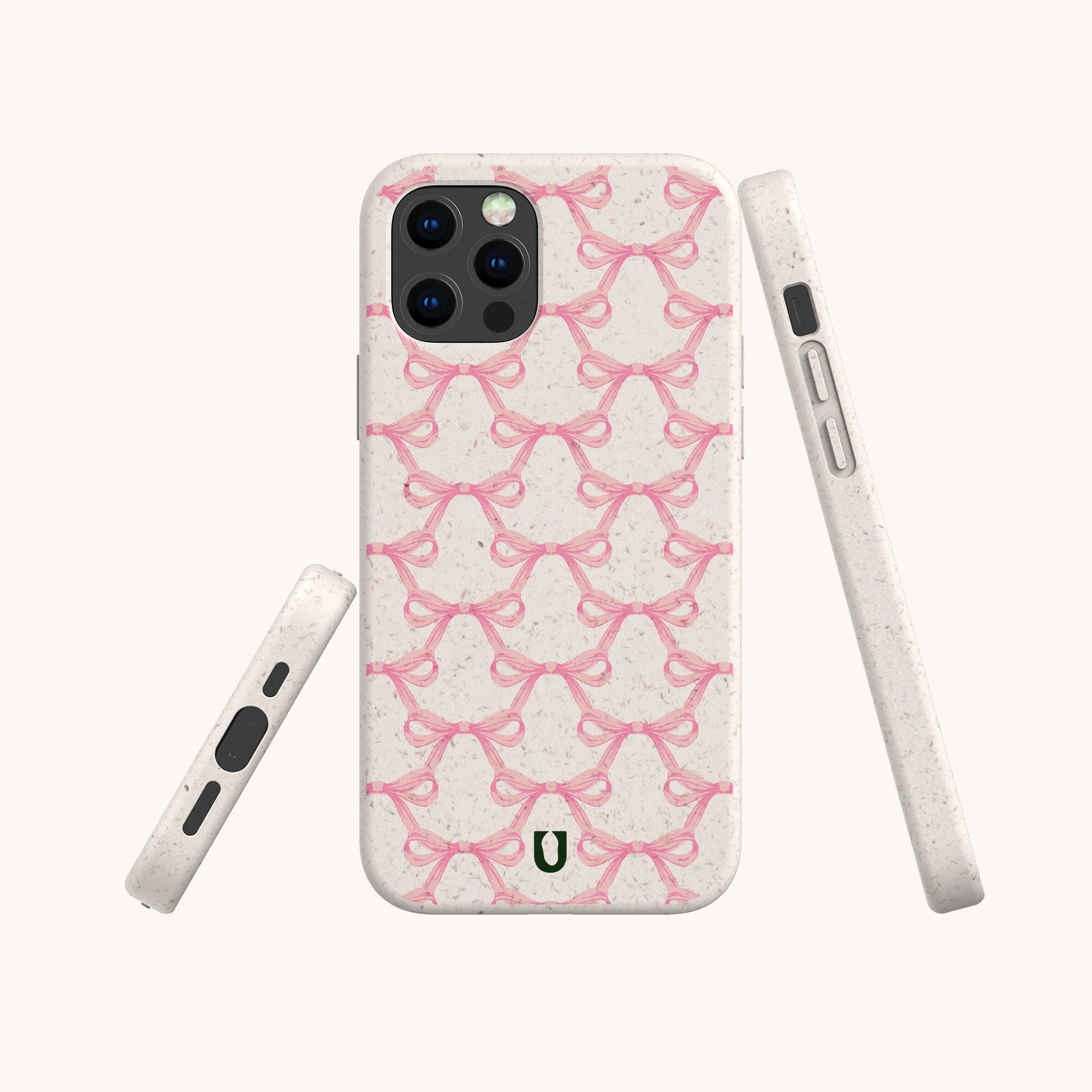 The Pink Bow Ribbons Eco-Friendly Biodegradable Phone Case features a beige, speckled texture, a repeating pink bow pattern, and a small green horseshoe logo at the bottom. Shown from multiple angles against a plain background.