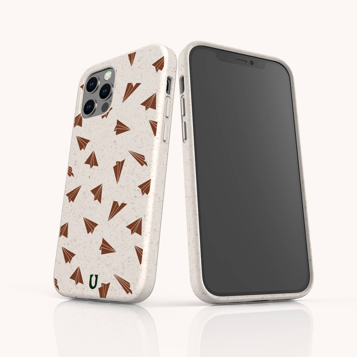 Two Paper Planes Eco-Friendly Biodegradable Phone Cases in beige are shown on smartphones—one displaying the back and one the front. Both cases feature brown paper airplane patterns and a small green U logo at the bottom, set against a plain white background.