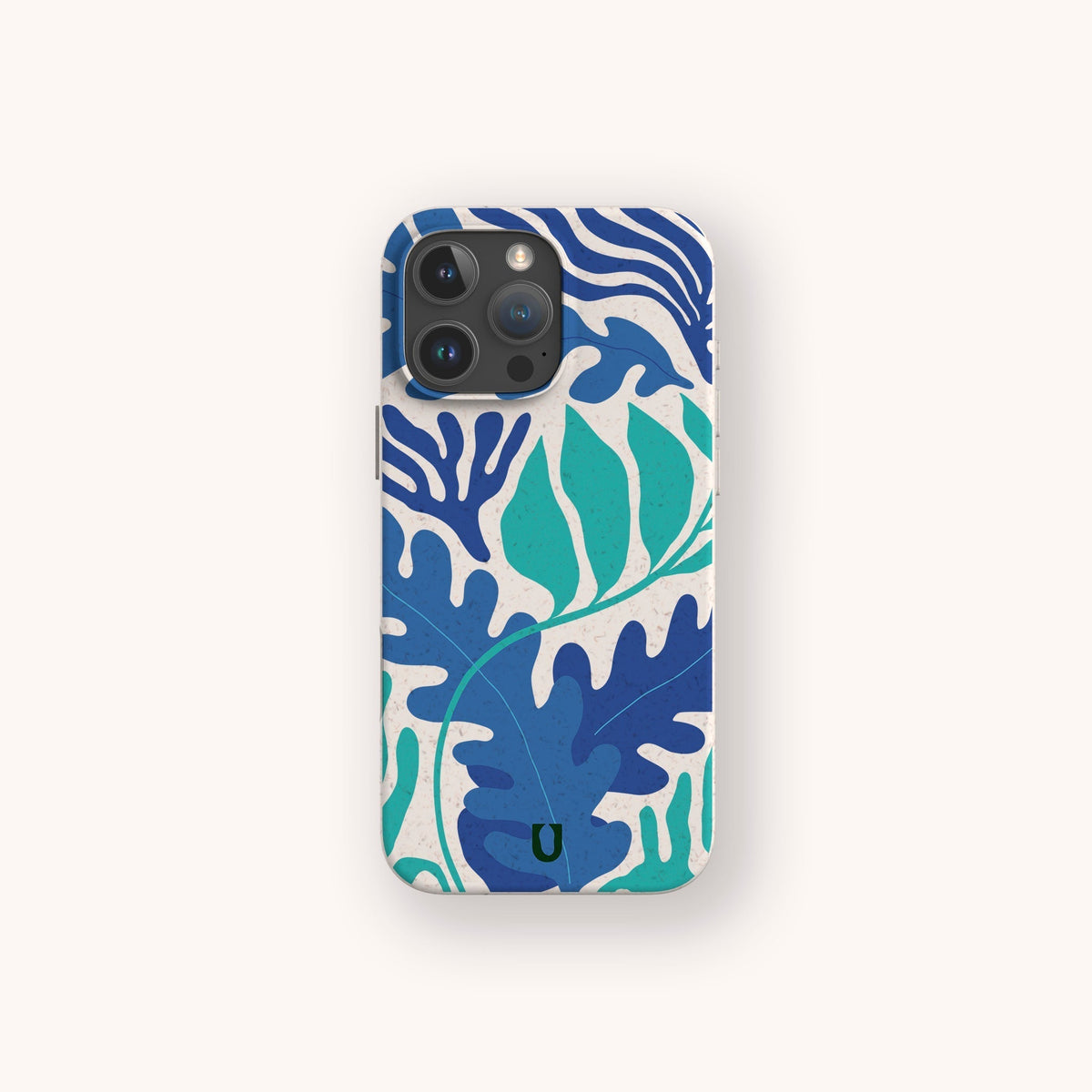 The Sea Bed Eco-Friendly Phone Case showcases bold blue and teal leaf patterns on a cream background, inspired by the ocean and crafted with sustainability in mind, shown against a light backdrop.