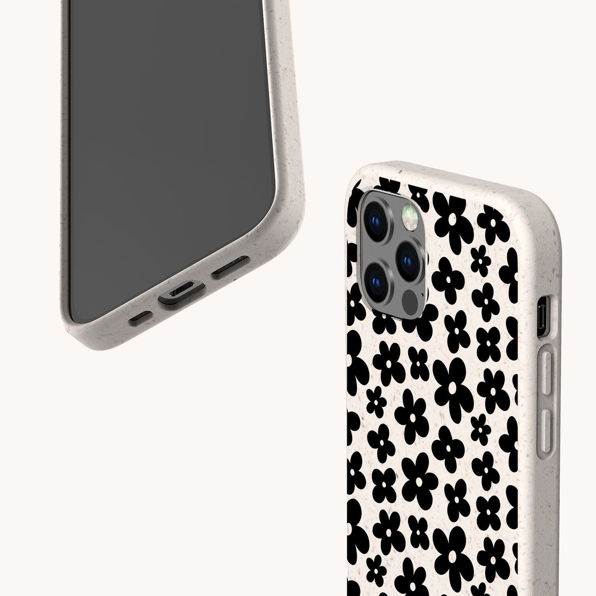Two smartphones with speckled white cases are displayed; one reveals its screen and bottom ports, while the other showcases the back adorned with the Black Flower Power Eco-Friendly Phone Case—a chic black floral pattern. Both stylish devices rest against a plain light background, blending modern elegance with the retro charm of the Black Flower Power Eco-Friendly Phone Case.