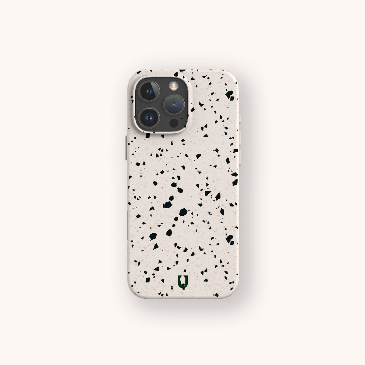 A smartphone with the Black Terrazzo Eco-Friendly Phone Case—a beige, compostable cover featuring a black speckled terrazzo pattern—is displayed against a light, neutral background.