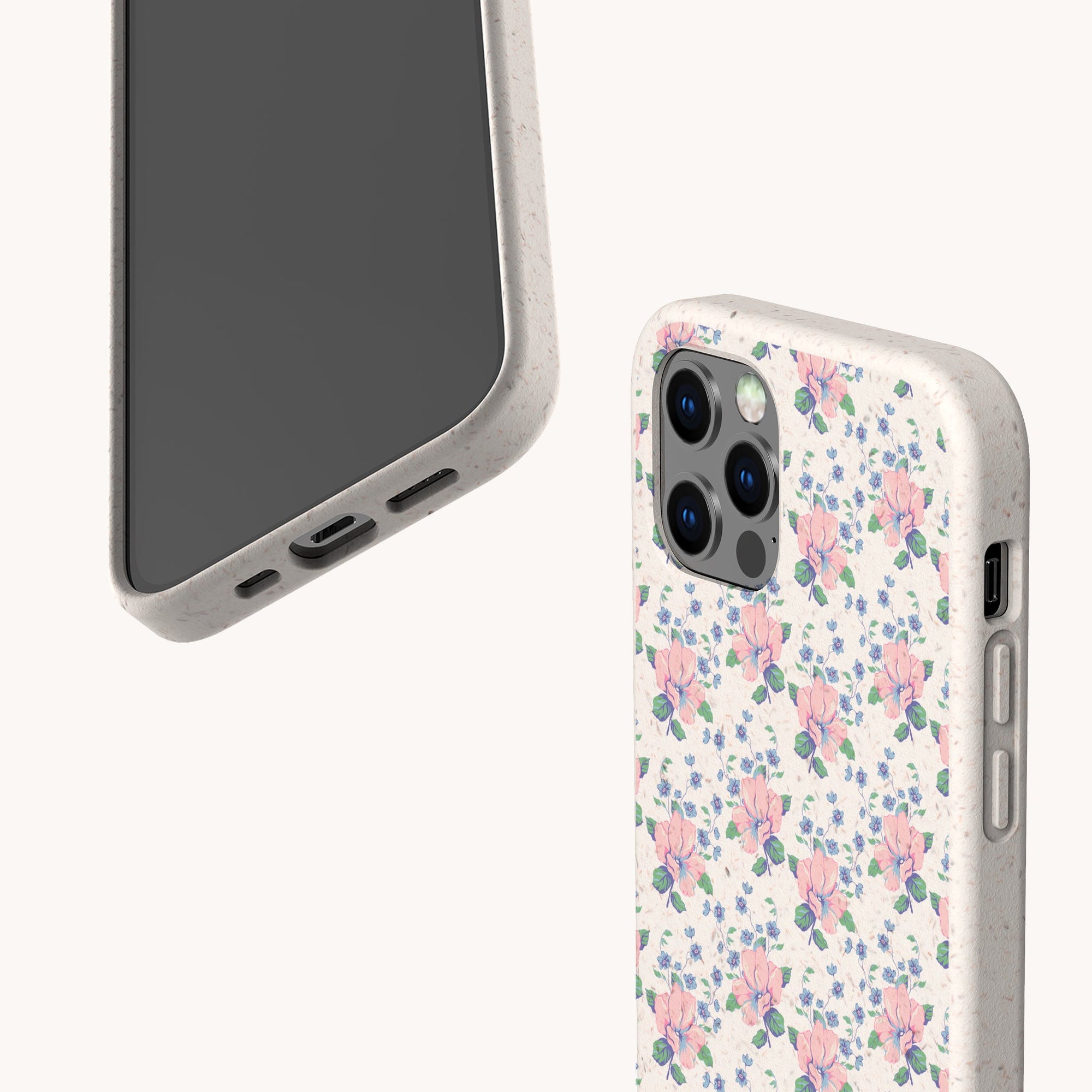 Two smartphones in beige cases; one displays the screen, the other showcases the Pink Coquette Flowers Eco-Friendly Biodegradable Phone Case with pink and blue flowers and green leaves, all on a neutral background.
