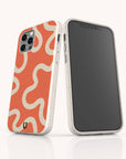 Two smartphones in white speckled cases; one features the Orange Swirl Eco-Friendly Biodegradable Phone Case with wavy cream lines, while the other displays a blank screen. These Sustainable Phone Cases offer rounded edges and an eco-friendly texture.