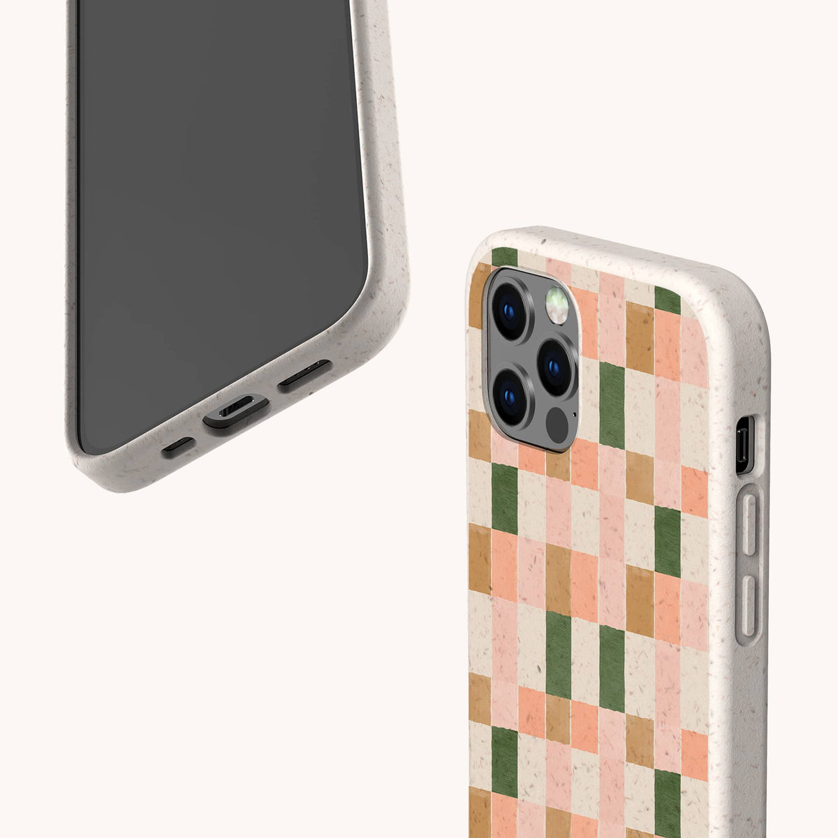 Two smartphones in speckled beige cases. One is the Pink and Green Watercolour Eco-Friendly Phone Case, featuring a pink, orange, and green checkered pattern reminiscent of a watercolour design; the other is plain. Both show camera cutouts and ports on a plain off-white background—perfect examples of eco-friendly phone case design.