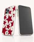 Two smartphones in white, each fitted with Burgundy Stars Eco-Friendly Biodegradable Phone Cases adorned with vibrant red star patterns. One phone is turned to display the back, highlighting the striking red stars and eco-friendly design, while the other phone faces forward with a blank screen. The backdrop is plain white.