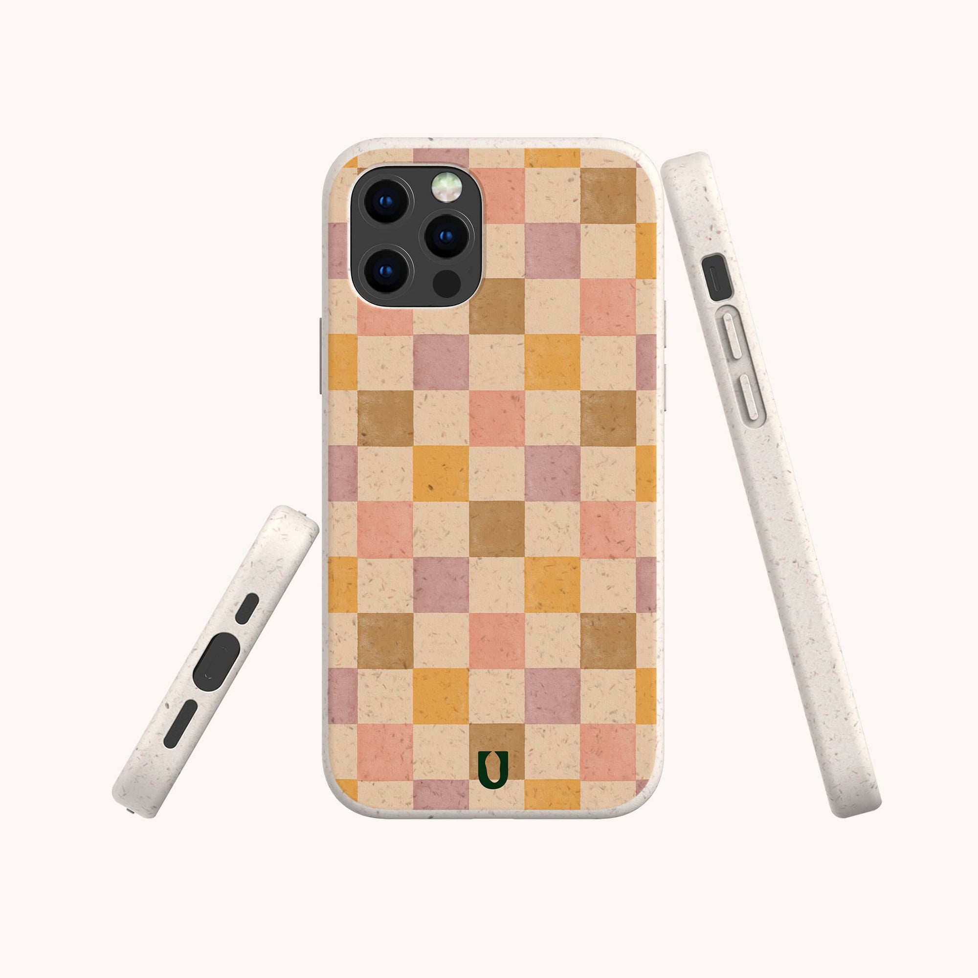 The Pink and Purple Checker Eco-Friendly Phone Case is shown from the back, side, and bottom. This compostable case features a pink and purple checkerboard pattern, rounded edges, and a small green horseshoe logo near the bottom.